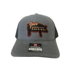 A gray baseball cap with the Joe's Kansas City Bar-B-Que pig logo in orange and black on the front.
