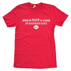 Kansas City BBQ T-shirt featuring the slogan "BBQ Is Not a Verb in Kansas City" on a red graphic tee, perfect for barbecue lovers and KC BBQ fans.